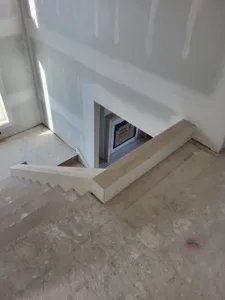 Painted white notched skirt board profile cut to match stair treads, staged in a framed floor opening