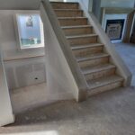Finished risers and treads installed on interior staircase with drywall skirt boards, ready for paint.