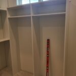 Face-frame closet shelving system with adjustable shelves, vertical dividers, and hanging rod spaces—primed and ready for paint.