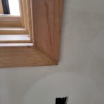 Finished wood casing and jamb installed on doorway opening with stained wood trim, ready for paint.