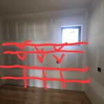 Rough drywall room with layout marks for upcoming trim or shelving installation.