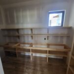 Custom built-in bookcase with raw wood shelves and brackets, ready for finishing.