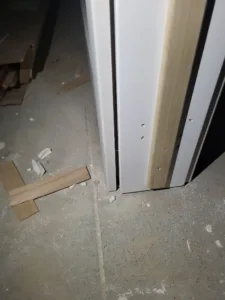 Door jambs and casing installation in progress on a concrete floor with mixed finish states.