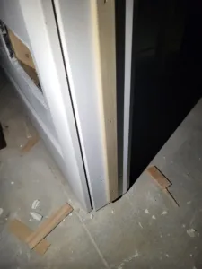 Door slab hung during trim stage, with jamb extensions and casing on one side