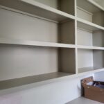 Custom built-in bookcase with face-frame shelving, painted white, ready for use.