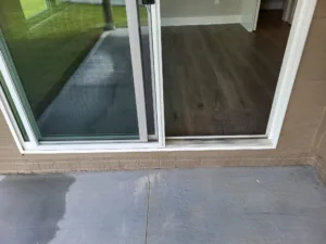 White framed sliding glass patio door installed with threshold and interior casing trim