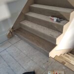 Finished stair skirt board and treads installed, raw wood stain applied, ready for paint.
