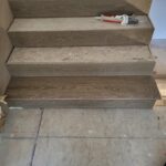 Finished wood stair risers and treads installed, raw wood stage before paint.