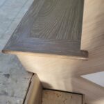 Dark wood threshold meeting light LVP flooring with finished edge detail and clean joinery.
