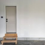 Painted interior door with three-panel slab, white casing, and black lockset hardware installed in finished opening.
