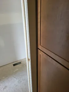 Stained wood interior door installed with white painted casing and jamb