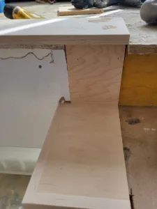 Cabinet door slabs in raw wood and primed finish staged on site for installation