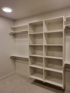 Finished closet shelving with cubbies, open shelves, and hanging rods on two walls