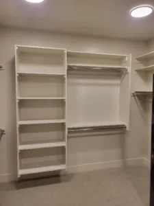 Finished closet with white face frame shelving, multiple hanging rods, and tiered shelf storage