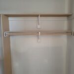 Closet shelf and hanging rod installed with white support brackets on side wall.