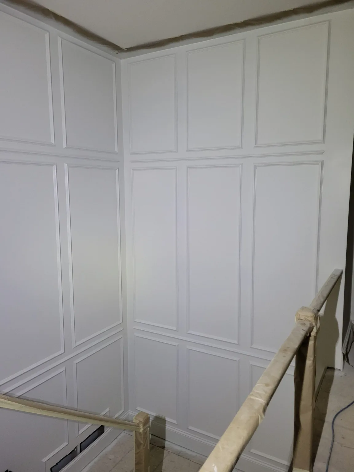 Floor-to-ceiling paneled wainscoting wrapping a stairwell