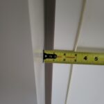 Measuring painted door jamb or casing edge during quality check or fit verification.