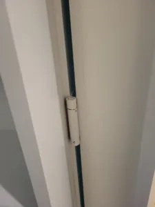 Closed painted white door edge showing a narrow vertical seam, finish stage complete