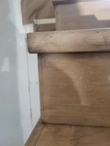 Unfinished wood handrail with rounded profile, raw wood ready for stain or paint