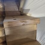 Custom-fabricated plinth block with cap detail at door base, raw wood finish ready for paint.