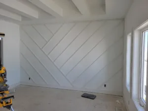 Diagonal wood plank accent wall, fully painted white with evenly spaced parallel lines