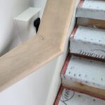 Close-up of a finished wood nosing detail on a staircase, showcasing the craftsmanship and smooth edges before final finishing.