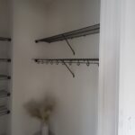 Wire shelving and hanging rod system installed in closet with white painted walls and support brackets.