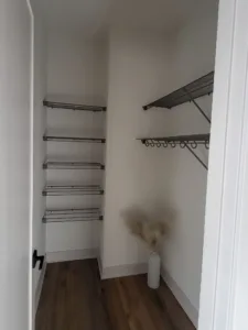 Completed closet with wire shelving, chrome hanging rods, and wood laminate flooring, painted walls