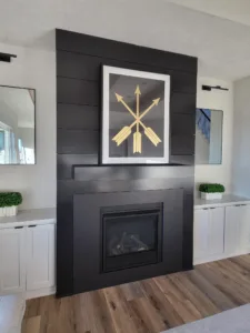 Black horizontal shiplap fireplace wall with an insert and white built-in cabinets on either side
