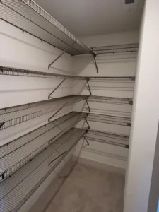 White wire shelving installed in closet with multiple tiers and metal support brackets, finished.