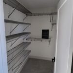 Wire shelving and hanging rods installed in closet with painted walls and ceiling.