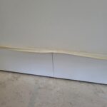 Raw wood baseboard installed at wall-floor junction, ready for paint or stain.