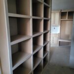 Custom built-in shelving with face-frame construction and open cubby compartments, raw wood ready for finish.