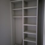 White face-frame closet shelving unit with multiple shelves, painted and installed in wall recess.
