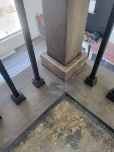 Finished wood clad column base with iron baluster rods and decorative trim installed