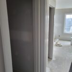 Painted cased opening with white trim and jamb, no door slab—pass-through between rooms.