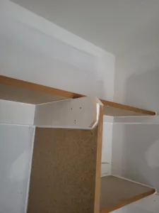 Closet shelf under construction, particle board with bullnose edge banding on a white bracket