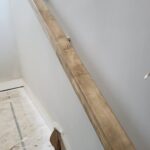 This photo shows the installation of skirt boards along a staircase, highlighting the raw wood before finishing. The work is currently in progress.