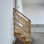 This photo shows a partially constructed handrail for garage steps, with raw wood framing visible during installation.