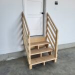 This photo shows a completed wooden stair with a handrail, ready for final finishing. The structure is sturdy and well-constructed.