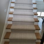 Completed stair treads with wood nosing, painted risers, and installed carpet runner.