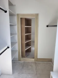 Light wood cased opening into a closet with interior shelving visible, hanging rods flanking the doorway.
