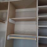 Closet shelving and hanging rod assembly with particle board shelves and wood cleats, unfinished.