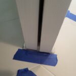 Painted door jamb and casing with protective tape applied during finish stage.