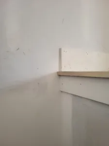 Closet shelf and support bracket installed on drywall, ready for paint