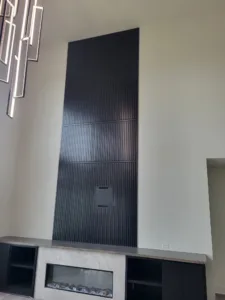 Vertical fluted panel fireplace wall with horizontal trim dividers and outlet cutout