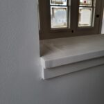 White painted window sill with bullnose edge installed at interior window opening.