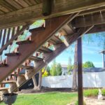 Finished wood pergola structure with stained beams and decorative overhead lattice detail.