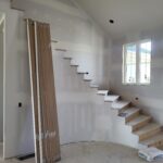 Iron baluster railing Step 1: drilled holes in treads and handrail ready for epoxy install; balusters staged separately for painting.