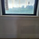 Wood window sill installed below exterior window frame, raw wood finish ready for paint.